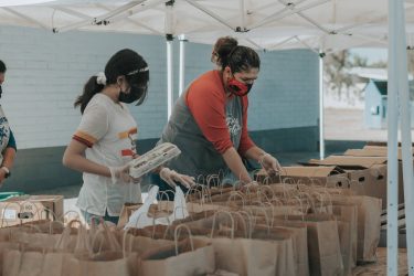 Volunteers sorting groceries into bags at a food bank.
